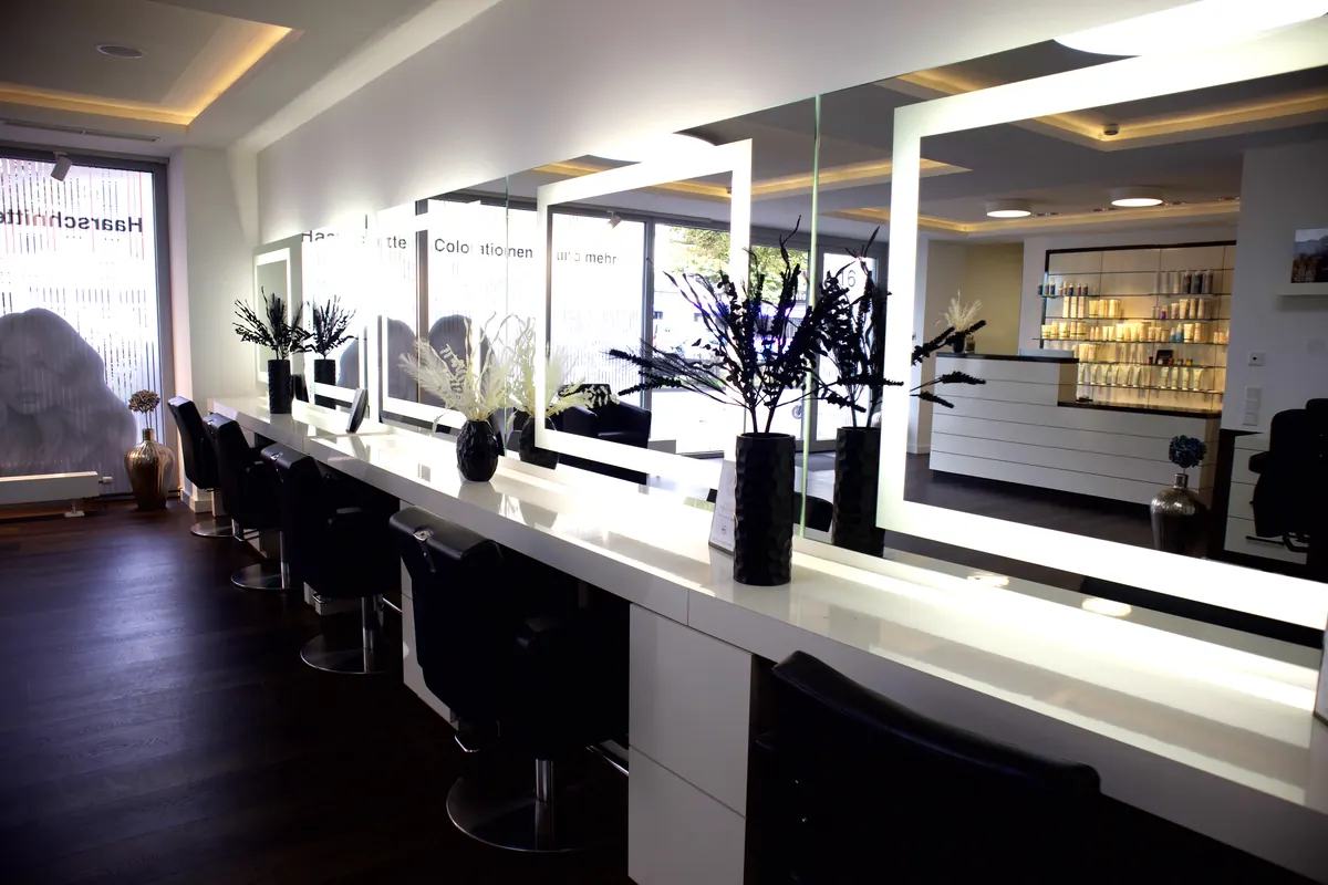 Lange Reihe von Frisierplätzen mit Lichtspiegeln bis zum Schaufenster